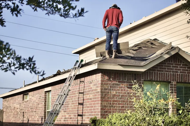 Professional roofer working on a residential roof in Ridgemar